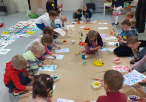Dzieci z grupy Skrzatów wykonują swoje abstrakcyjne pracy używając kolorowych farb.