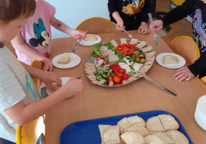 Dzieci z grupy Skrzatów wybierają produkty do koponowania własnych kanapek na śniadanie.
